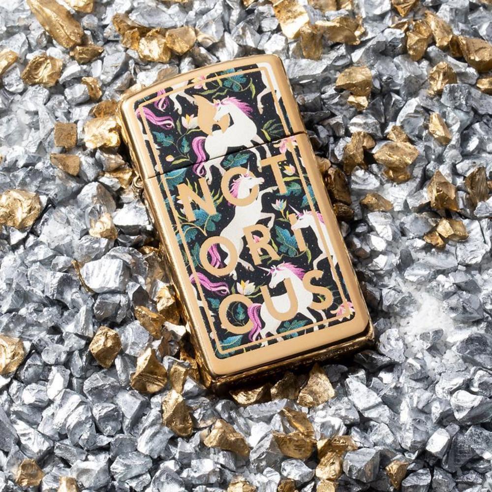 Lifestyle image of Notorious Unicorn Design laying on gold and silver pebbles