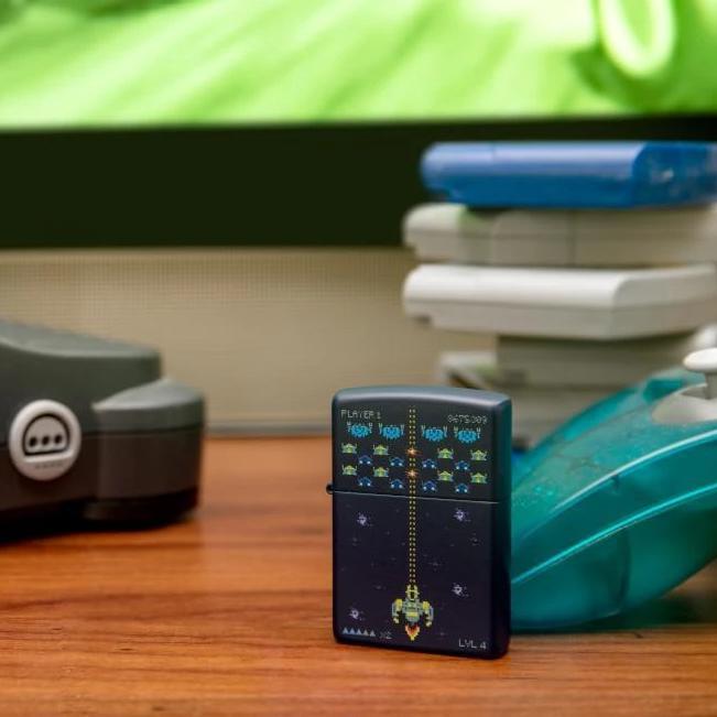 Lifestyle image of Pixel Game Design Windproof Lighter standing on a table with a nintendo 64 controller 