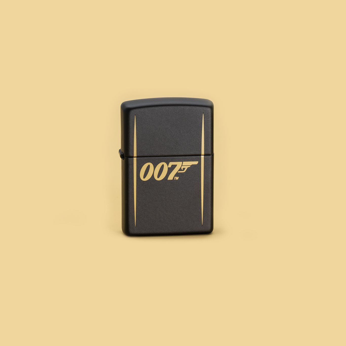 Lifestyle image of James Bond 007?äó Laser Engraved Black Matte Windproof Lighter standing in a yellow scene.